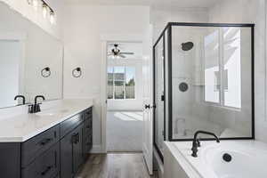 Bathroom featuring ceiling fan, hardwood / wood-style floors, vanity, and separate shower and tub