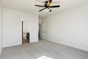 Unfurnished bedroom featuring ceiling fan, carpet, and ensuite bath