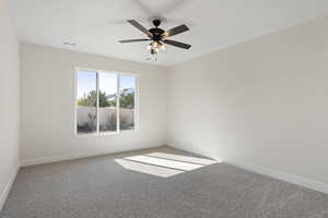 Spare room featuring ceiling fan and carpet