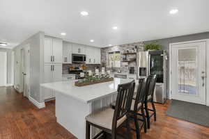 Updated kitchen with large quartz island, new cabinets with pull out shelves. Back door goes to patio