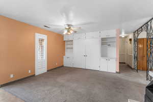 Family room with ceiling fan, light colored carpet, and a textured ceiling