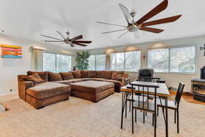 Sunroom featuring a ceiling fan and a wood stove