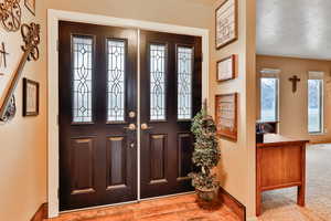 Foyer with light wood-type flooring and a textured ceiling