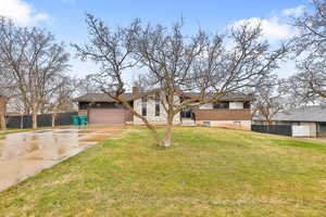 View of front facade featuring a front yard and a garage