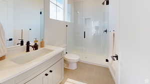 Bathroom featuring an enclosed shower, vanity, tile patterned floors, and toilet