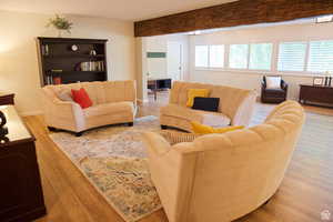 Living room featuring beam ceiling and light wood-type flooring