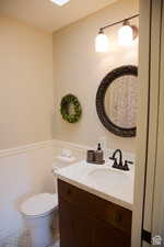 Bathroom with toilet, vanity, a skylight, and tile patterned floors