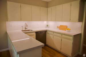 Kitchen featuring white cabinetry, dishwasher, dark hardwood / wood-style floors, and sink