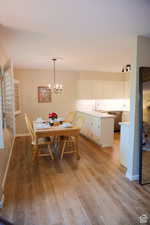 Dining area featuring sink, a chandelier, and light wood-type flooring