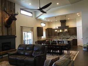 Living area featuring a towering ceiling, plenty of natural light, a fireplace, and dark wood finished floors