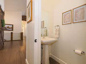 Bathroom with hardwood / wood-style flooring, sink, and lofted ceiling