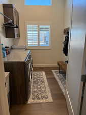 Laundry area featuring dark wood-style floors, washing machine and dryer, cabinet space, and baseboards