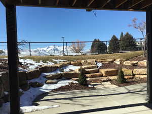 Snow covered patio featuring fence