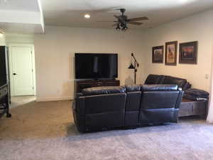 Carpeted living room featuring ceiling fan, recessed lighting, and baseboards