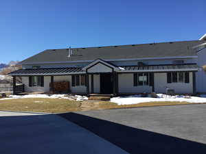 View of front of property with a standing seam roof, metal roof, and roof with shingles