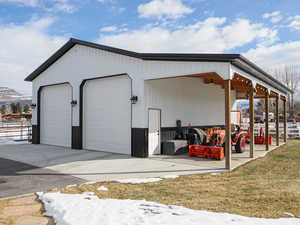 View of outdoor structure with a garage, a yard, and a mountain view