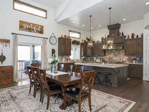 Dining room featuring a healthy amount of sunlight, dark hardwood / wood-style flooring, and a high ceiling