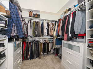 Walk in closet featuring light colored carpet