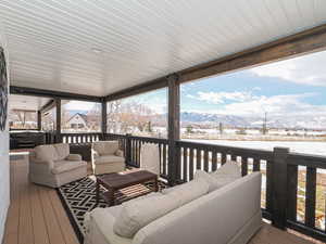 Snow covered deck featuring a mountain view and outdoor lounge area