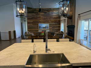 Kitchen featuring a fireplace, light countertops, open floor plan, wood walls, and wood finished floors