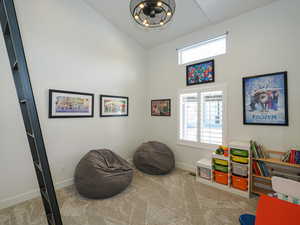 Living area featuring carpet floors, a healthy amount of sunlight, vaulted ceiling, and a notable chandelier