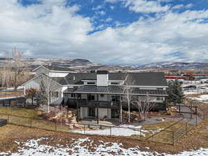 Snow covered house with a deck with mountain view