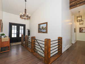 Entrance foyer featuring a notable chandelier, beamed ceiling, high vaulted ceiling, french doors, and dark hardwood / wood-style flooring