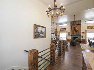 Hall featuring a wealth of natural light, a towering ceiling, and dark hardwood / wood-style floors