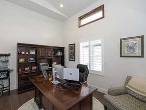 Home office featuring lofted ceiling and dark hardwood / wood-style floors