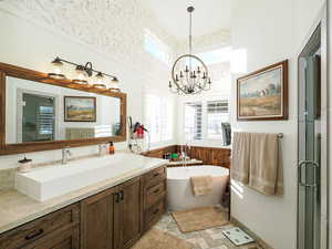 Bathroom with plus walk in shower, a chandelier, and vanity