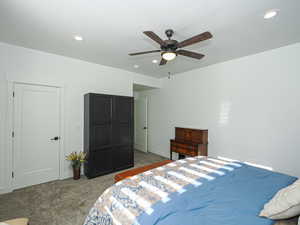 Carpeted bedroom featuring ceiling fan