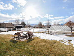 View of yard with a fire pit, a mountain view, and an outdoor structure