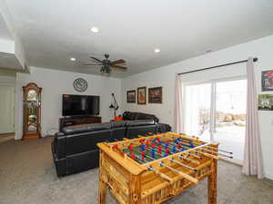 Playroom featuring light carpet, ceiling fan, and a textured ceiling