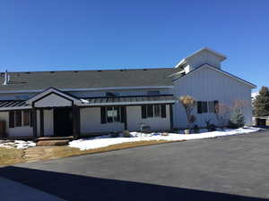 View of front of property featuring a standing seam roof, roof with shingles, and metal roof