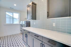 Laundry room with cabinets and washing machine and clothes dryer