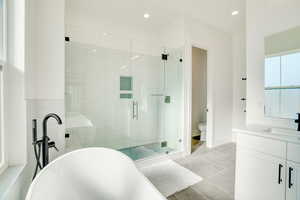 Bathroom featuring separate shower and tub, vanity, and tile patterned flooring