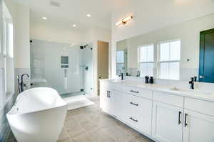 Bathroom featuring plus walk in shower, tile patterned flooring, and vanity