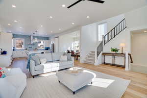 Living room featuring ceiling fan, a wealth of natural light, and light hardwood / wood-style flooring