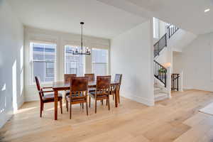 Dining area featuring light wood-type flooring, a chandelier, and plenty of natural light