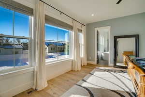 Bedroom with ensuite bathroom and light hardwood / wood-style flooring