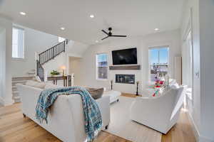 Living room with ceiling fan and light wood-type flooring