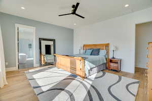 Bedroom with ceiling fan, ensuite bathroom, and light wood-type flooring