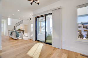 Entryway featuring ceiling fan with notable chandelier and light hardwood / wood-style flooring