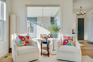 Sitting room with light hardwood / wood-style flooring and a notable chandelier