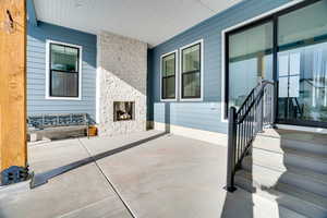 View of patio with an outdoor stone fireplace