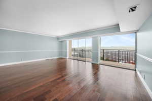 Unfurnished room with hardwood / wood-style floors and crown molding