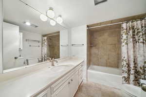 Full bathroom with toilet, vanity, and shower / tub combo with curtain