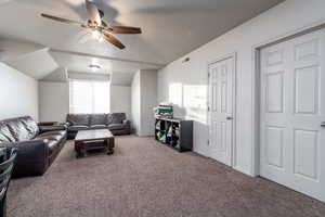 Carpeted living room featuring ceiling fan and a textured ceiling