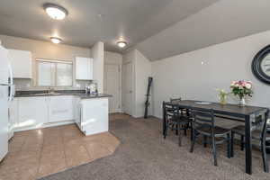 Kitchen featuring a textured ceiling, white cabinets, and tile patterned flooring