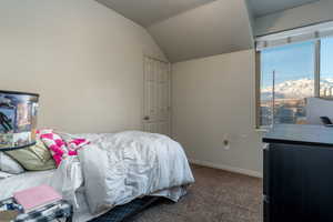 Carpeted bedroom featuring lofted ceiling and a mountain view